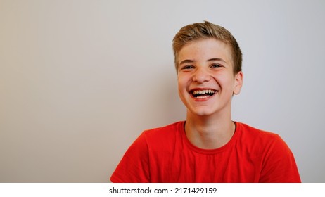 Happy positive teenage boy laughing at funny joke looking at camera on the wall background. Cheerful teen having fun, smiling face. Headshot close up portrait. - Powered by Shutterstock