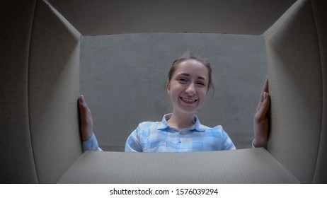 Happy Positive Woman In Plaid Shirt Opening Cardboard Box With Gift, Looking Inside And Smiling - Pov Low Angle View. Unboxing, Unpacking, Holiday, Birthday, Celebration, Emotions, Surprise Concept