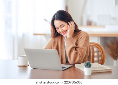 Happy Positive Young Asian Woman Enjoying Online Communication At Home, Female Using Wifi While Video Conferencing With Friend, Sitting In Front Of Open Laptop, Copy Space.