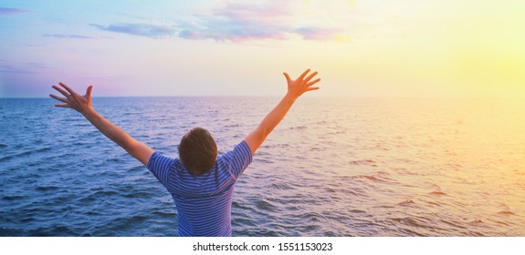 Happy prayer man with open outstretched arms. Sunset sea and clouds in light blue morning sky. Christian worship praise god, financial freedom life hope victory enthusiasm mental health concept banner