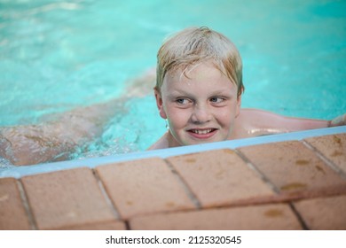 Happy Pre Teen Boy Swimming In Backyard Pool