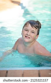 Happy Pre Teen Boy Swimming In Backyard Pool