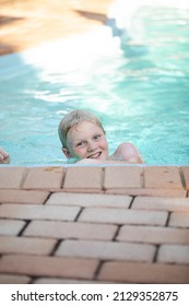 Happy Pre Teen Boy Swimming In Backyard Pool