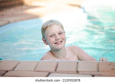 Happy Pre Teen Boy Swimming In Backyard Pool