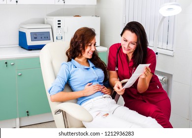 Happy pregnant woman in the gynecologist's office. Doctor and patient watching baby