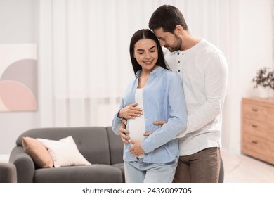 Happy pregnant woman with her husband at home, space for text - Powered by Shutterstock