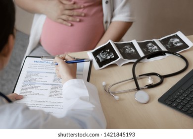 Happy Pregnant Woman Visit Gynecologist Doctor At Hospital Or Medical Clinic For Pregnancy Consultant. Doctor Examine Pregnant Belly For Baby And Mother Healthcare Check Up. Gynecology Concept.