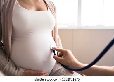 Gute Schwangere besuchen Gynäkologe im Krankenhaus oder in der medizinischen Klinik für schwangere Berater. Der Arzt untersucht schwangere Bauchmuskulatur auf die Untersuchung des Gesundheitszustands bei Säuglingen und Mutter. Gynäkologie-Konzept. 