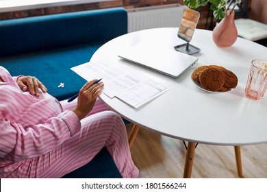 Happy Pregnant Woman Writing In Her Pregnancy Calendar, At Home. Keeping A Journal, Expecting Baby