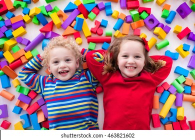 Happy Preschool Age Children Play With Colorful Plastic Toy Blocks. Creative Kindergarten Kids Build A Block Tower. Educational Toys For Toddler Or Baby. Top View From Above.