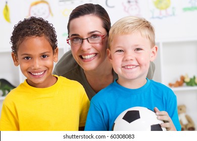 Happy Preschool Teacher And Two Boys In Classroom