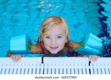 Happy Preschooler Girl Learning To Swim In Community Swimming Pool. Little Swimmer Enjoying Group Lesson At Sport School.