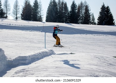 Happy Preteen Child, Jumping With Ski In A Snow Fun Park. Kid Skiing In Italy On A Sunny Day, Kids And Adults Skiing Together. Family Vacation