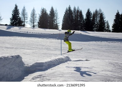 Happy Preteen Child, Jumping With Ski In A Snow Fun Park. Kid Skiing In Italy On A Sunny Day, Kids And Adults Skiing Together. Family Vacation