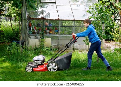 Happy Preteen Kid Boy With Lawn Mower. Portrait Of Smiling Teenager Child Working In Garden, Trimming Grass. Garden Works In Summer. Kid Helping