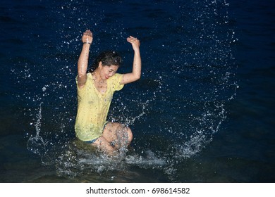 Happy pretty Asian woman open arms having fun in the sea playing at night.