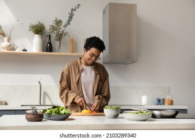 Happy Pretty Black Girl Enjoying Cooking Hobby, Chopping Fresh Vegetables For Salad At Kitchen Table, Making Healthy Dinner From Organic Bio Ingredients, Keeping Vitamin Rich Nutrition