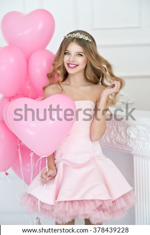 Happy pretty girl with pink balloons smiling and laughing at birthday party. 