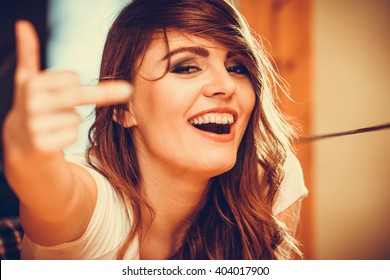 Happy Pretty Gorgeous Woman Giving Middle Finger Gesture Sign. Attractive Young Girl With Long Curly Hair. Instagram Filter.