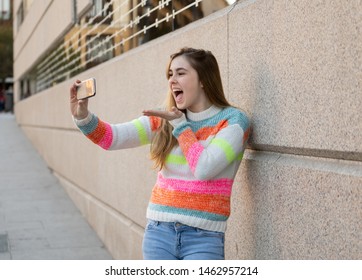 Happy pretty teenager girl using smart mobile phone excited blowing a kiss and waving to followers friends or family recording video or chatting. Video call In technology Communications and Blogging. - Powered by Shutterstock