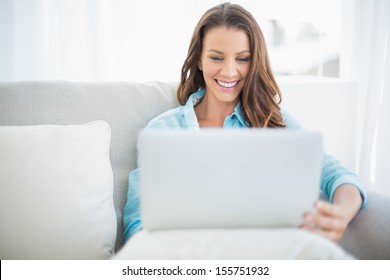 Happy Pretty Woman Using Laptop Sitting On Cosy Sofa