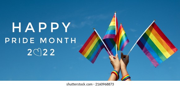 'HAPPY PRiDE MONTH 2022' on bluesky and rainbow flags background, concept for lgbtq+ celebrations in pride month, june, 2022.
