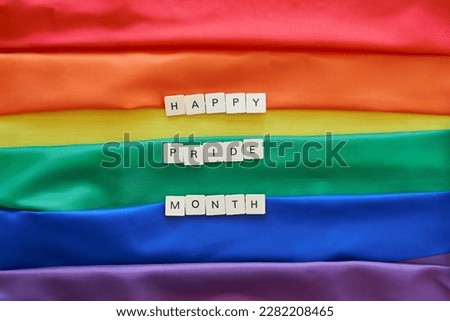 Happy Pride month concept. Happy pride month spelled with craft letters over lgbt rainbow flag