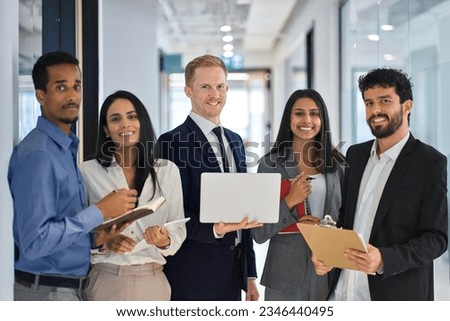 Happy professional international team young business people workers standing in corporate office, diverse multiethnic smiling employees colleagues company staff posing for team portrait together.