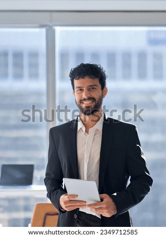 Happy professional young latin business man company employee, male corporate manager, businessman office worker looking at camera holding digital tablet standing in office, vertical portrait.