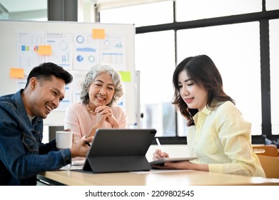 Happy And Professional-aged Asian Female Boss Or Executive Manager, Satisfied With Her Marketing Campaign Results In The Meeting With Her Marketing Team.