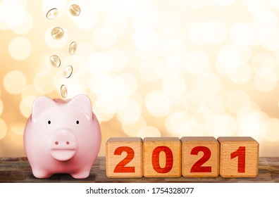 Happy Prosperous New Year concept with wealthy piggy bank and wood cube blocks New Year 2021. Bokeh Christmas holiday background with copy space.