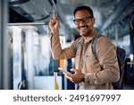 Happy public transport passenger using smart phone during the ride and looking at camera. Copy space.