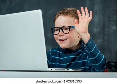 Un bon élève de l'école primaire a une leçon en ligne. Le garçon a un zoom vidéo avec son professeur. L'étudiant apprend l'anglais et l'informatique sur ordinateur portable à distance. L'enfant reste à la maison. Covid-19 coronavirus.