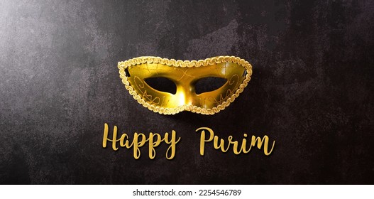 Happy Purim carnival decoration concept made from golden mask on dark background. (Happy Purim in Hebrew, jewish holiday celebrate) - Shutterstock ID 2254546789