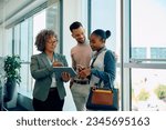 Happy real estate agent using digital tablet with her clients during consultations in the office. Copy space.