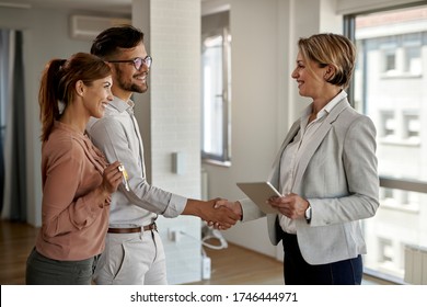 Happy real estate agent and young couple shaking hands after successful agreement.  - Shutterstock ID 1746444971