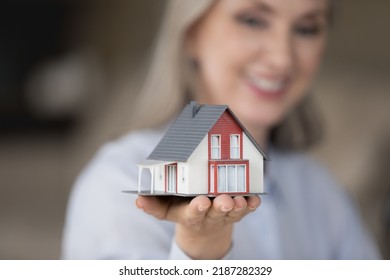 Happy Realtor Woman Holding Tiny House Model On Hand, Palm, Showing Object At Camera, Promoting Agency Service, Help With House, Property Buying Apartment Rent, Mortgage