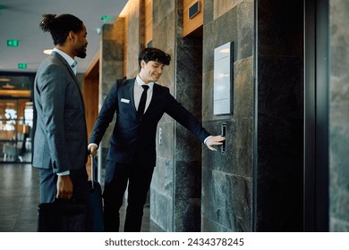 Happy receptionist assisting African American businessman who is checking in at the hotel.  - Powered by Shutterstock