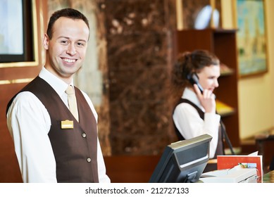 Happy Receptionist Worker Standing At Hotel Counter