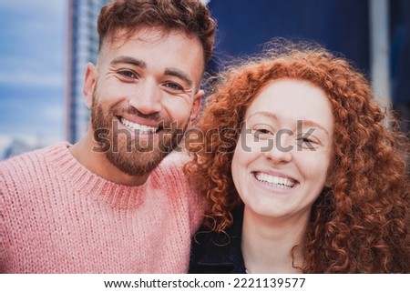 Happy red ginger hair brother and sister having fun doing selfie outdoor - Focus on faces