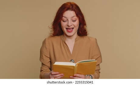 Happy redhead woman reading funny interesting fairytale story book, leisure hobby, knowledge wisdom, education, learning, study, wow. Young ginger girl isolated alone on beige studio background - Shutterstock ID 2255315041