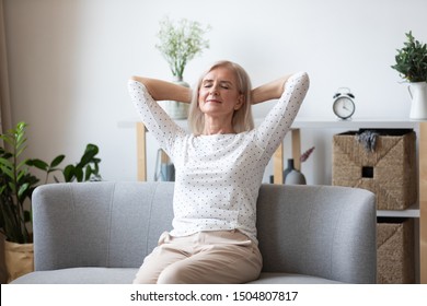 Happy relaxed older woman with closed eyes sitting leaning back on couch, calm mature female with hands behind head enjoying weekend, stretching on couch, resting and daydreaming, no stress concept - Shutterstock ID 1504807817