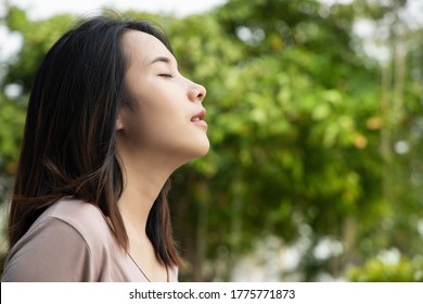 Happy entspannte Frau atmet frische Luft in grüner Umgebung