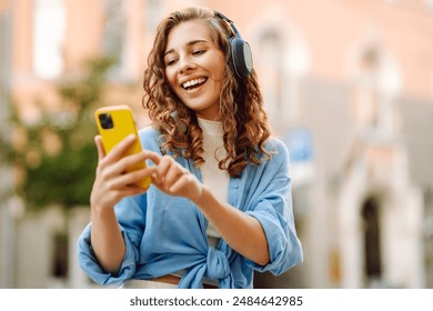 Happy relaxed woman in wireless headphones choosing, listening favorite music in urban city sunny street. Travel, tourism, technology, blogging concept. - Powered by Shutterstock