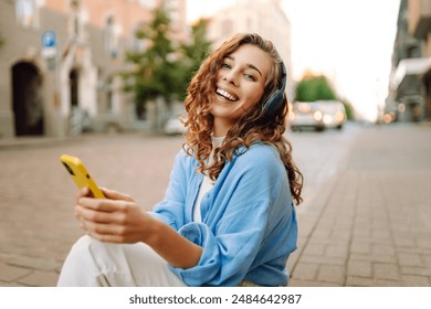 Happy relaxed woman in wireless headphones choosing, listening favorite music in urban city sunny street. Travel, tourism, technology, blogging concept. - Powered by Shutterstock