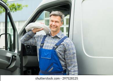 Happy Repairman With White Cable Coil Standing In Front Of Van