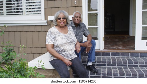 Happy Retired Black Couple Sitting Outdoors