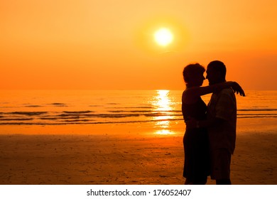 happy retired couple on the beach