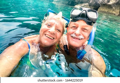 Happy Retired Couple With Scuba Mask Taking Selfie At Tropical Excursion - Boat Trip Snorkel Experience In Exotic Scenarios - Elderly Concept With Active Seniors Traveling Around World - Vivid Filter