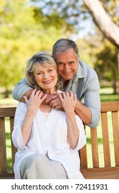 Happy Retired Couple Sitting On The Bench